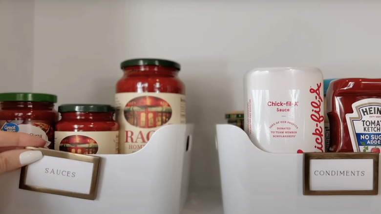 woman labeling pantry sauces