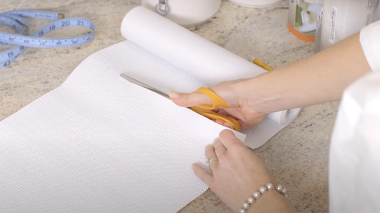 woman cutting shelf liner