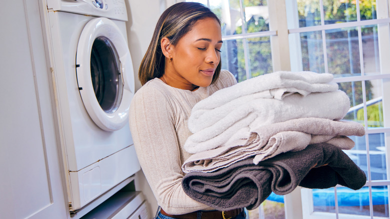 Person holding, smelling folded towels