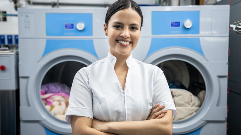 woman smiling in front of laundry machines 