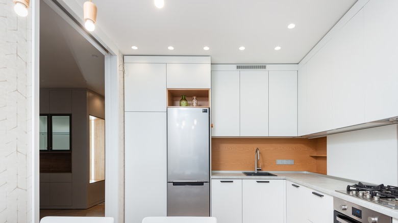 Fridge with small open cabinet on top of it