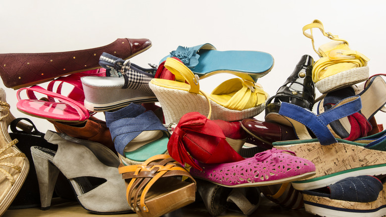 Piles of colorful women's shoes stacked on floor