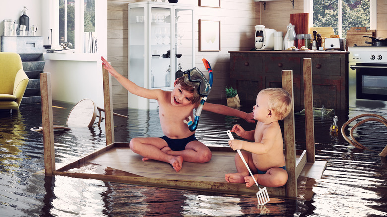 Kids paddle through a flooded kitchen