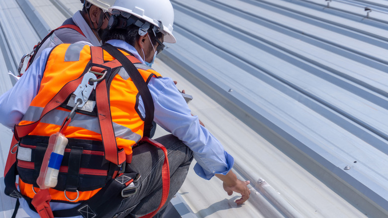 Worker points to metal roofing