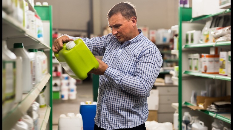 Man looking at fertilizer container in store