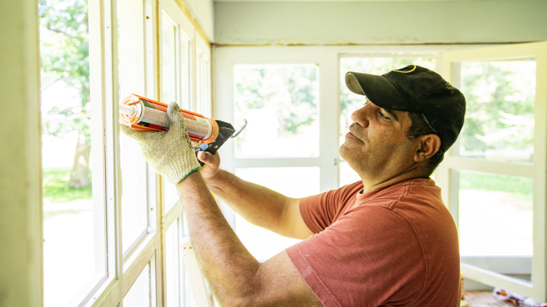 Man caulking windows