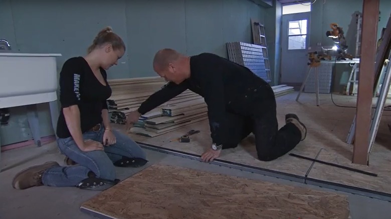 Mike Holmes and his daughter installing subfloor in a basement