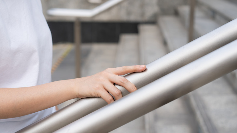 Woman grasping stair railing