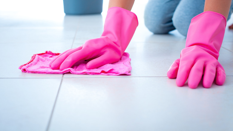 Woman wiping floor with pink microfiber cloth