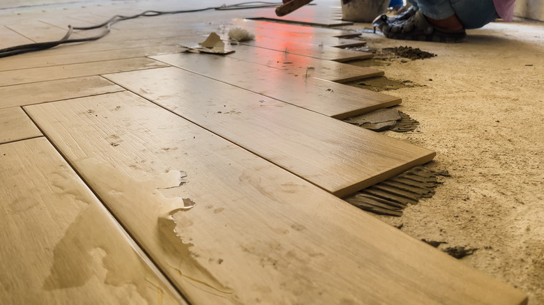 Tiler laying tiles in a herringbone pattern