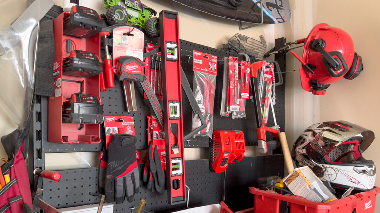 A collection of Milwaukee tools hangs in groups on a store wall