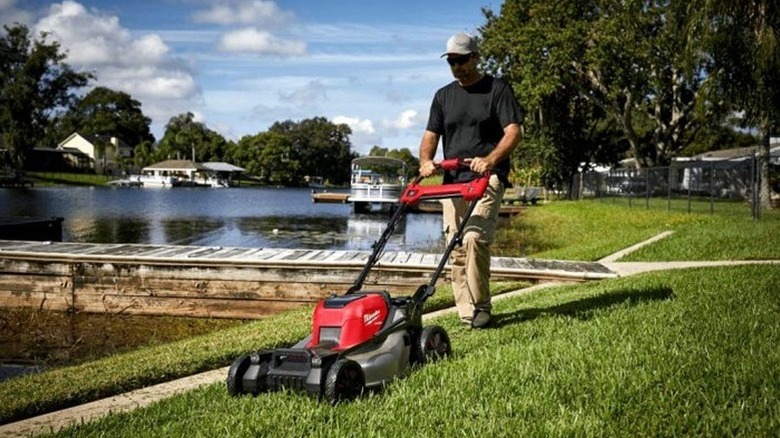 Man mowing with a battery-powered Milwaukee mower