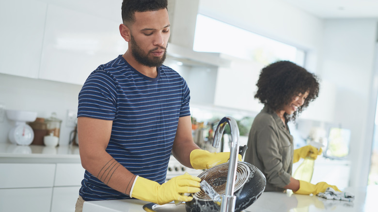 Couple cleaning kitchen