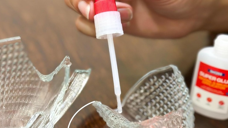 A person supergluing a glass bowl back together