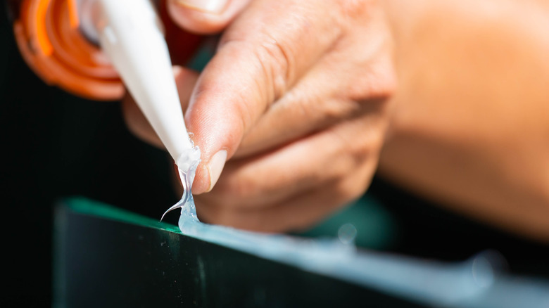 A person applying superglue to an object