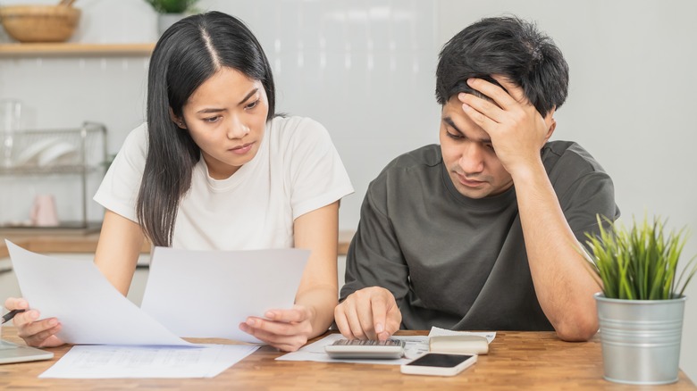 couple working with calculator and receipts