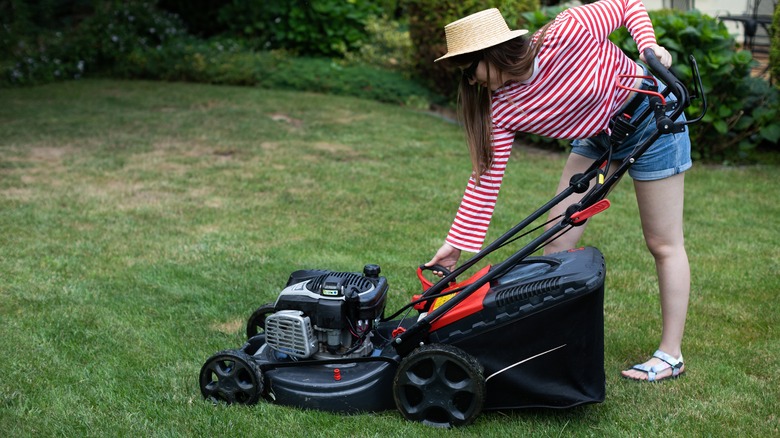 woman starting lawn mower