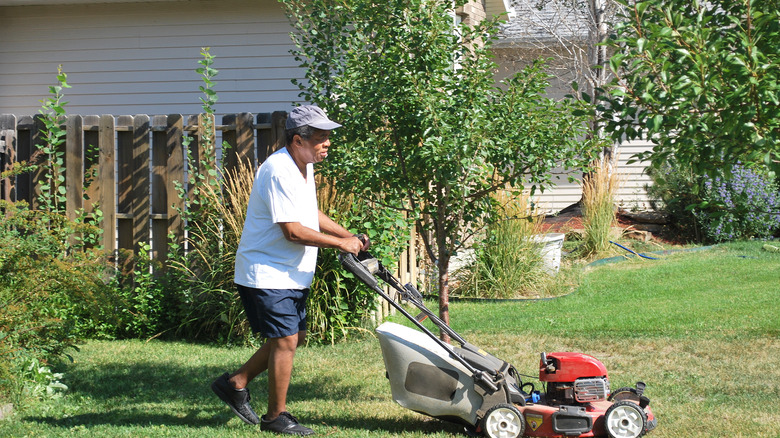 man with gas powered mower