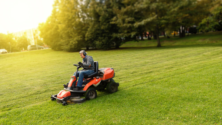 man safely mowing lawn