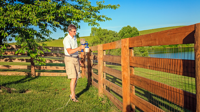 A man staining his fence