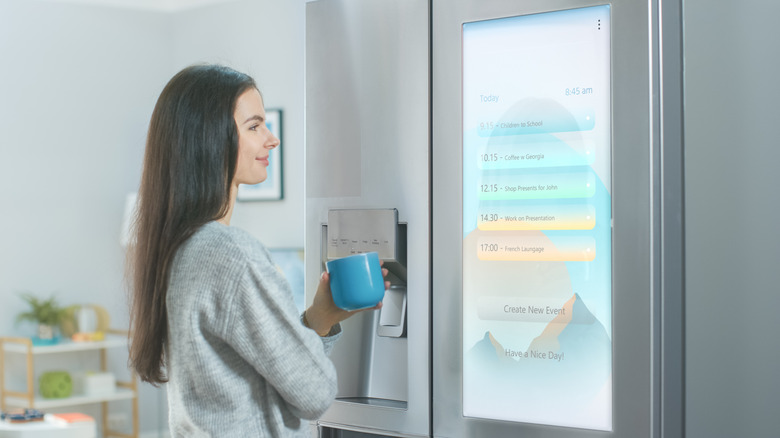 woman reading screen on refrigerator