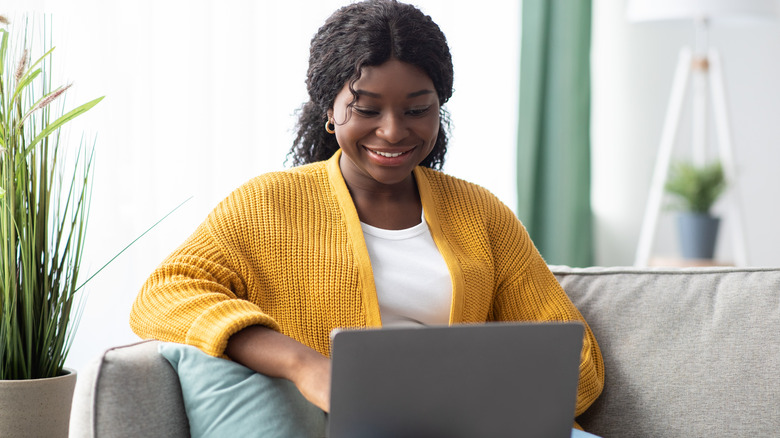 woman using laptop on couch