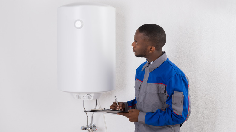 man inspecting small water heater