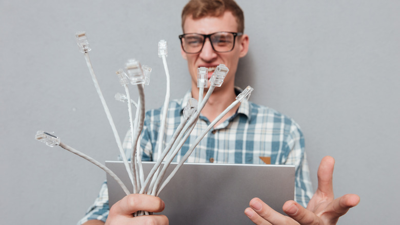 man holding cables and computer