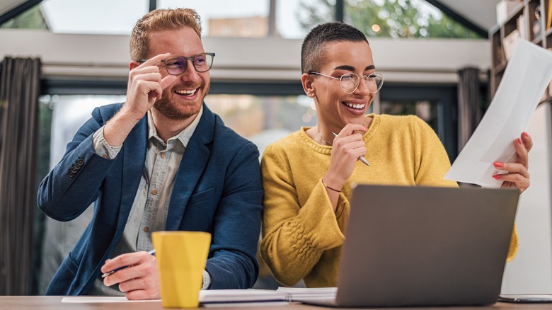 Man and woman smiling at paper