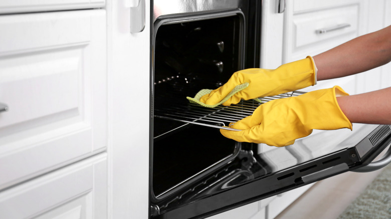 woman cleaning inside of oven