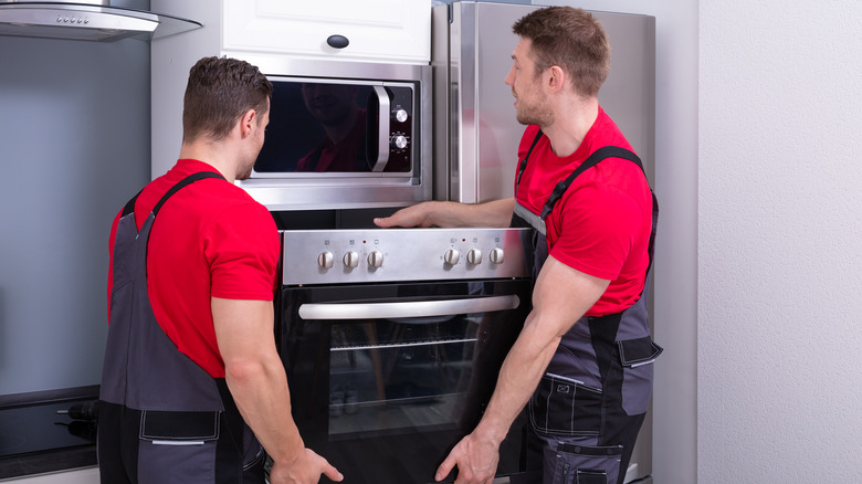 men installing a wall oven