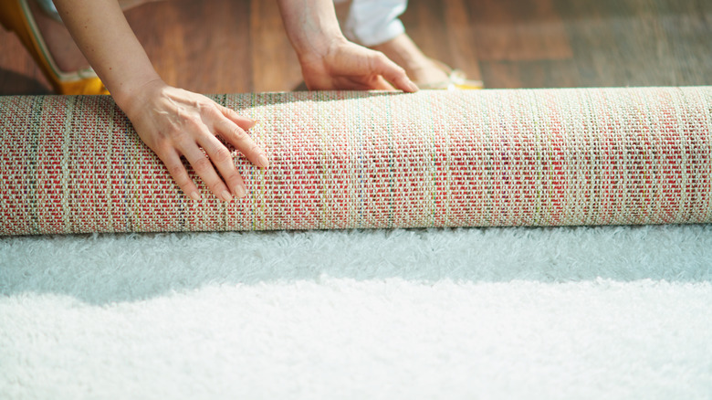 woman installing carpet on floor