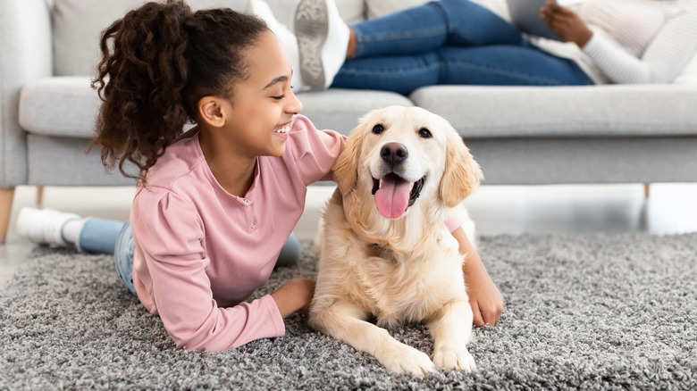 girl and dog on carpet