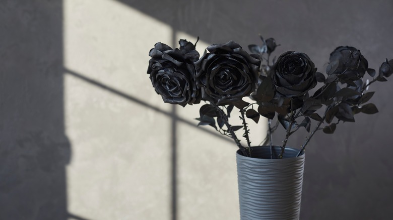 Black roses arranged in black vase