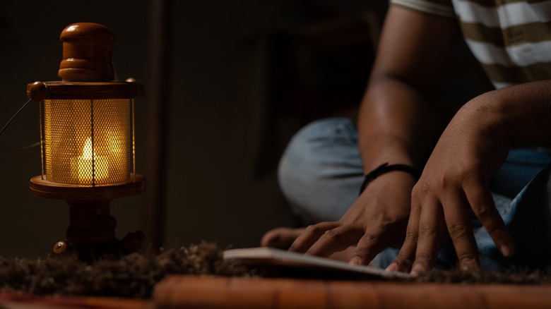 Reading by oil lamp