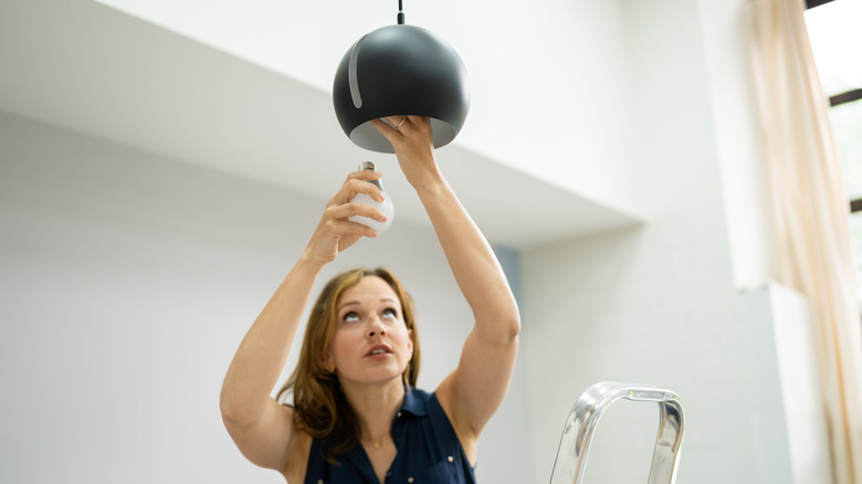 Woman installing light bulb