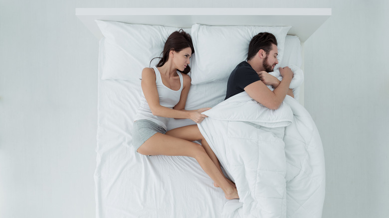 irritated couple in bed