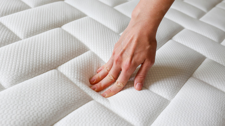 person touching top of mattress