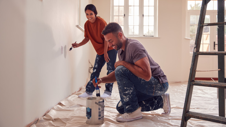 couple painting walls in home