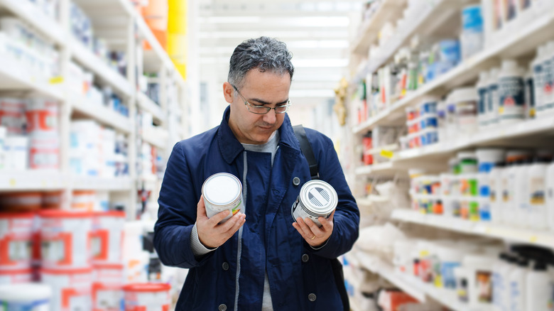 man buying paint in a store