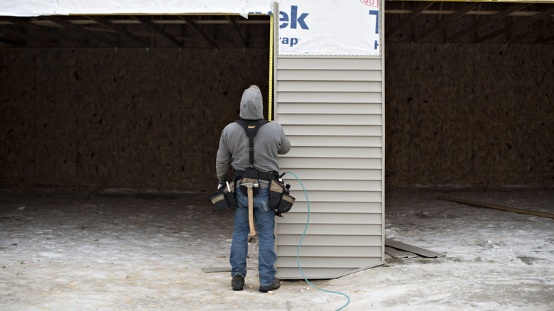 contractor measuring for siding installation