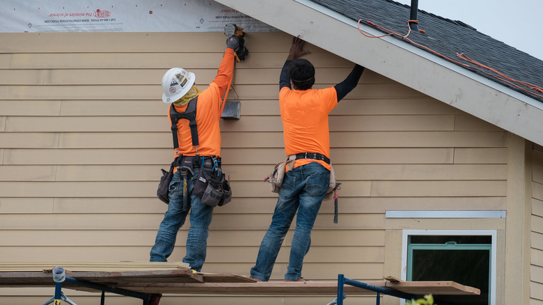 two people installing siding