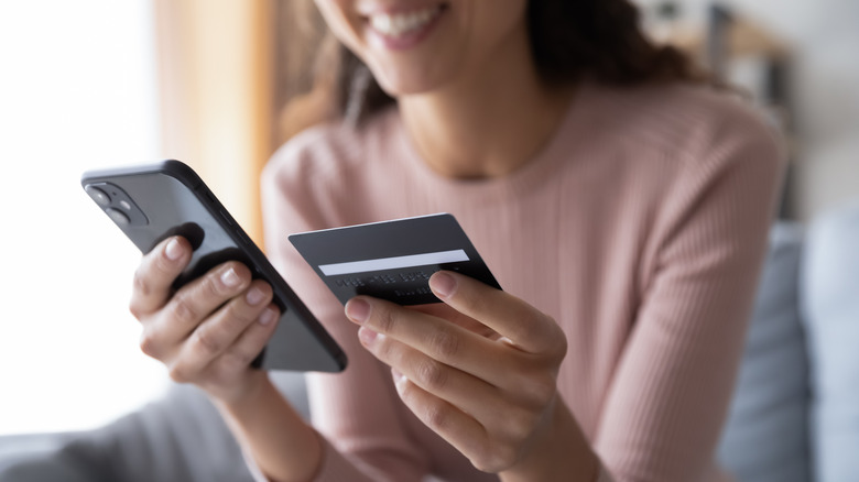 woman with phone and credit card