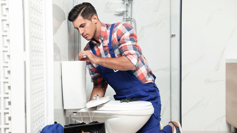 person repairing toilet