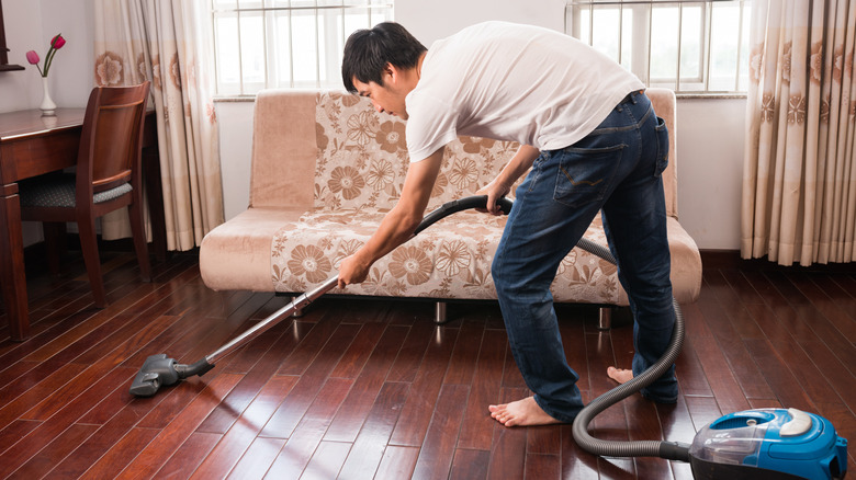 young man vacuuming floors