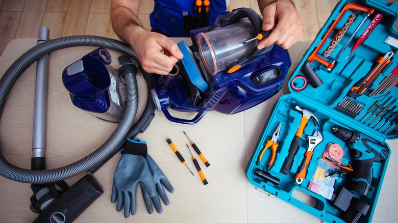 serviceman repairing a vacuum