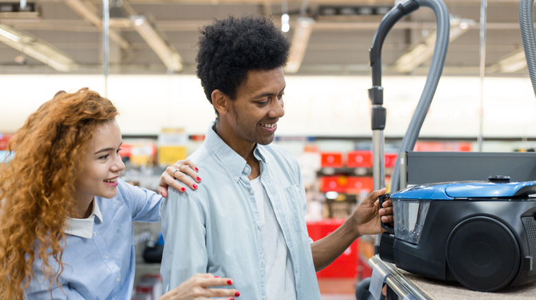 couple shopping for vacuum cleaner