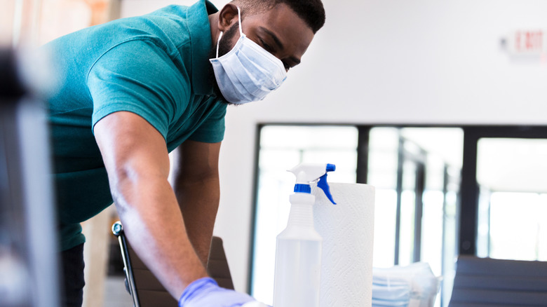 Person wearing mask and gloves for protection while cleaning