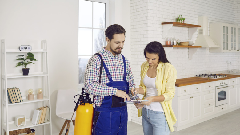 Exterminator explaining treatments to a homeowner