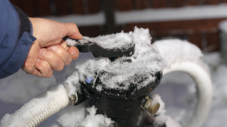 A person trying to open a frozen water pump